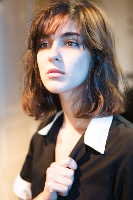 Sleazy maid Leonda A exposes her small nips and bushy beaver in a solo