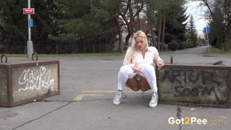 Natural blondie Katy Sky takes a piss on a paved road during the day