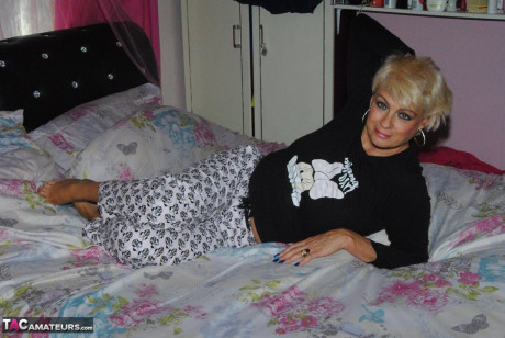 Mature blondie Dimonty doffs a shirt and pajama bottoms to get naked on her bed