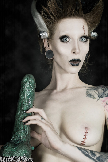 Tattoo model Razor Candi blows on a massive dildo in Bride of Frankenstein attire