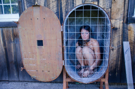 Female slave London River is restrained in a variety of ways in a yard