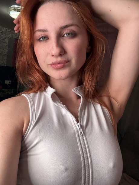 Redheaded amateur models white undergarment during a SFW photo shoot