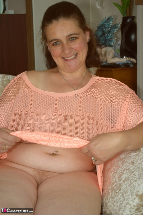 Redheaded BBW makes her naked modelling debut upon a sofa
