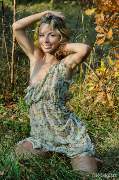 Young young blondy Natalia B takes off her dress to go totally nude in the woods