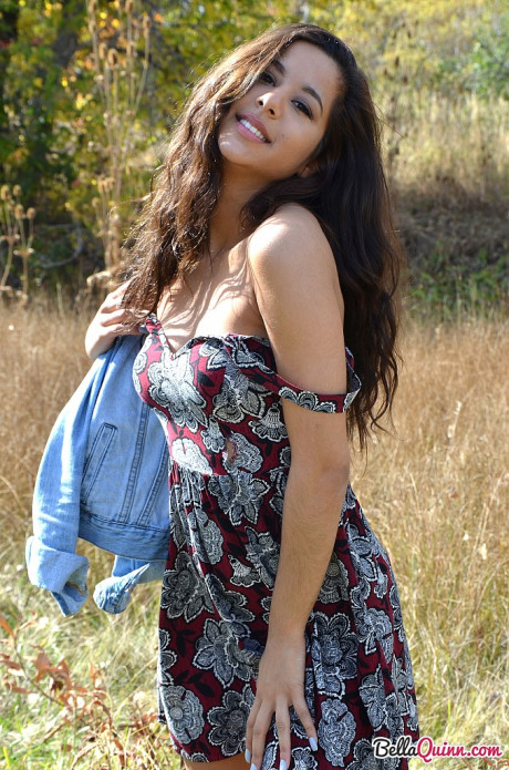 Latina first timer Bella Quinn covers up her exposed breasts in a field