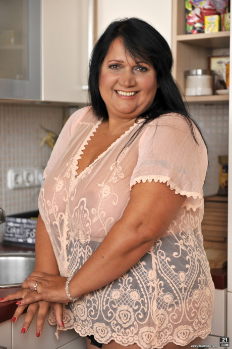 BBW brunette Bubi poses and displays her monstrous natural melons in a galley