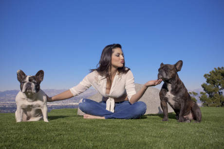 Sexy and cute brunette doll Sunny Leone poses outdoors in tight jeans