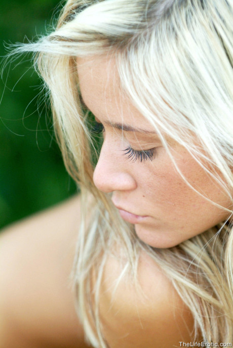 Naked blondy babe Jana H shows off her small titties & her tight ass outdoors