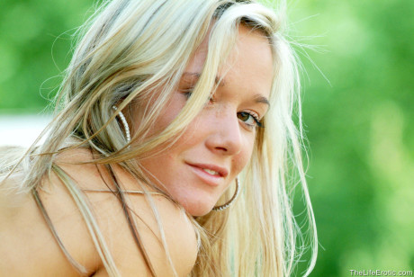 Naked blondy babe Jana H shows off her small titties & her tight ass outdoors