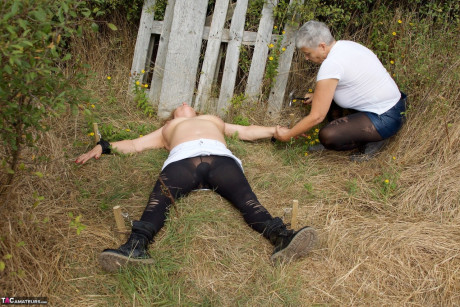 Mature British girl restrains busty old lady woman Speedy Bee while in the outdoors