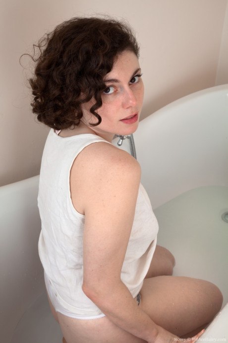 Brunette amateur Romy flaunts her giant butt and bushy twat in a tub