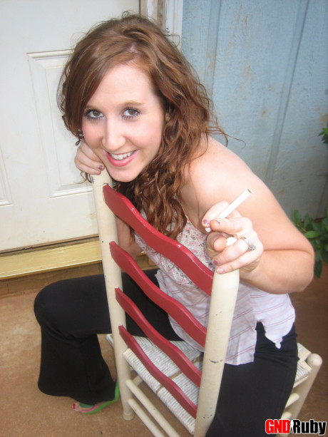 Young young ginger head flashes a boob while having a cigarette on a back porch