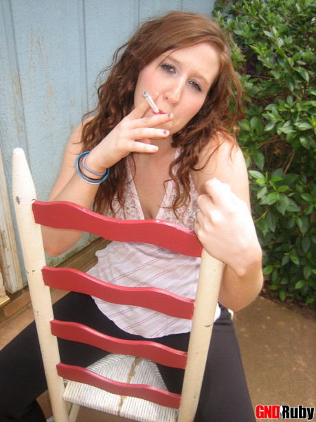 Young young ginger head flashes a boob while having a cigarette on a back porch