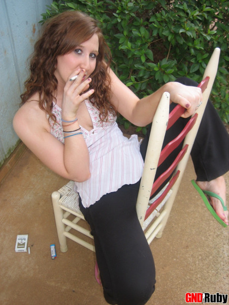 Young young ginger head flashes a boob while having a cigarette on a back porch