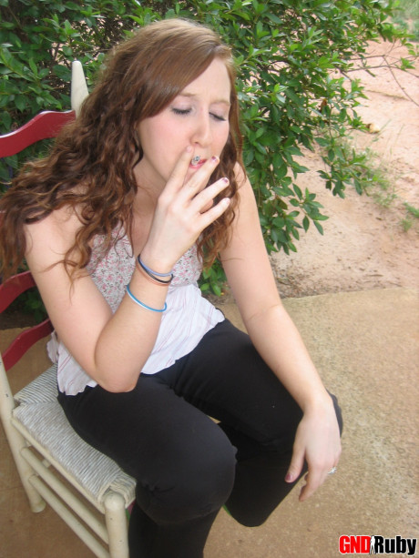 Young young ginger head flashes a boob while having a cigarette on a back porch