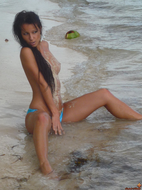 Beautiful girls work free of their swimwear while modeling on a tropical beach
