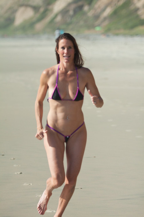 Pretty all-natural mature Sofie Marie runs on the beach in a very skimpy bikini