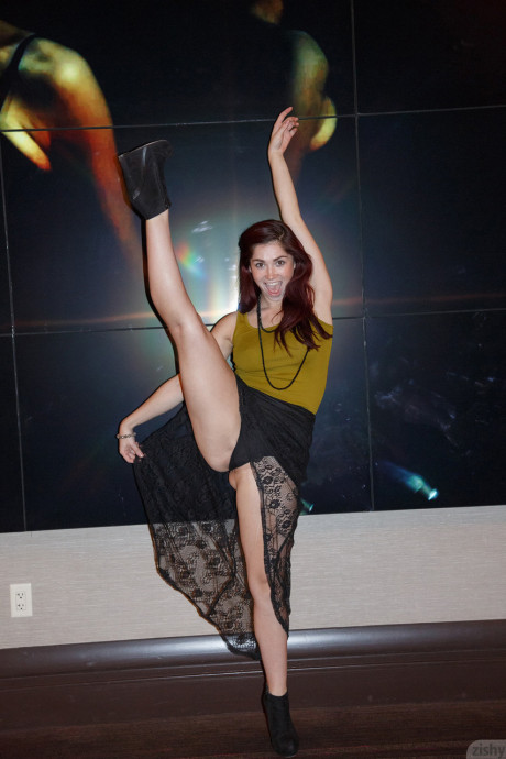 Redheaded babe Jazz Reilly gives an upskirt while showing her flexible body