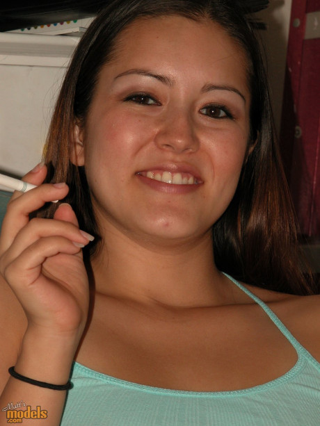Amateur model Kahna smokes a cigarette while showing her tits and vagina