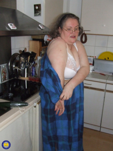 Chunky old housewife Birgid masturbates with a cucumber in the kitchen