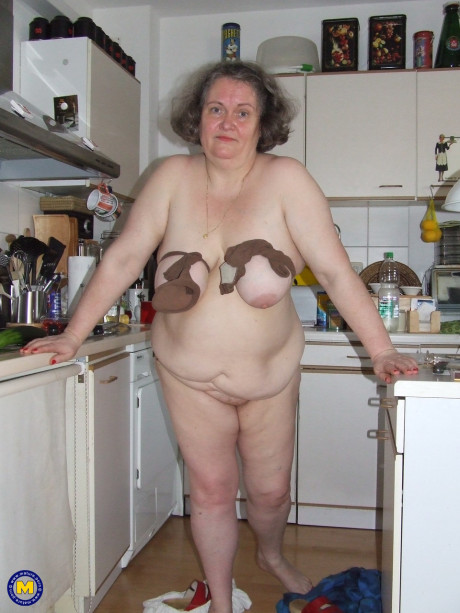 Chunky old housewife Birgid masturbates with a cucumber in the kitchen
