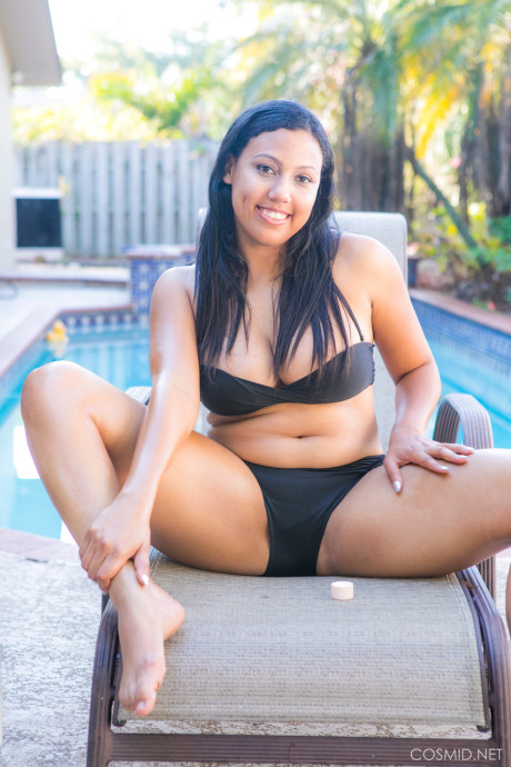 Chubby ebony amateur removes her bikini to pose undressed on chair by a pool
