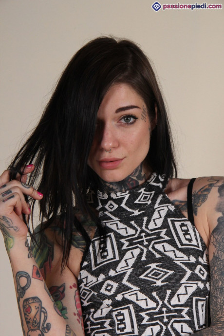Tattooed female shows off the soles of her feet wearing jean shorts
