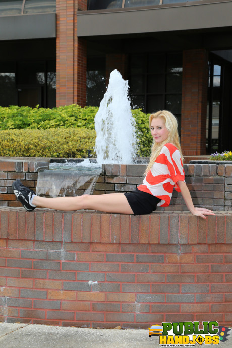 Yellow-haired Odette Delacroix shows her tiny melons while giving a handjob outdoors