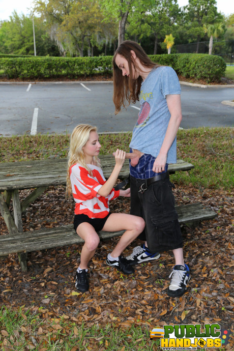 Yellow-haired Odette Delacroix shows her tiny melons while giving a handjob outdoors