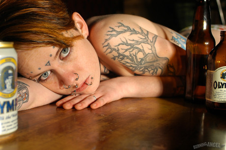 Babe with short hair and heavy tattoos is a striptease at an empty bar