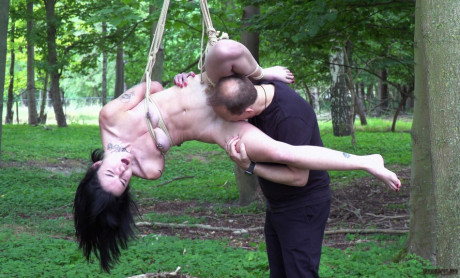 Nude brunette Crystal Cherry gives a blowjob after being flogged in the woods