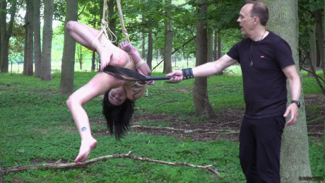 Nude brunette Crystal Cherry gives a blowjob after being flogged in the woods