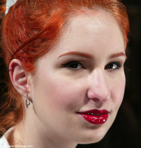 Pale ginger head is silenced and restrained with rope in a dungeon