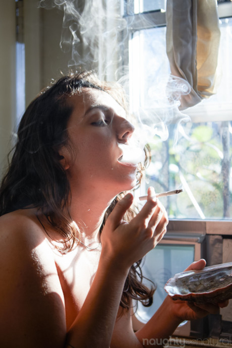 Amateur babe Nikki Silver smokes a spliff while posing undressed indoors and out