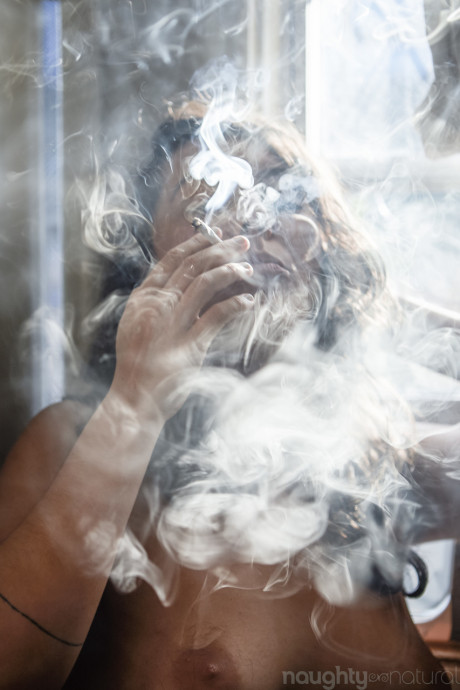 Amateur babe Nikki Silver smokes a spliff while posing undressed indoors and out
