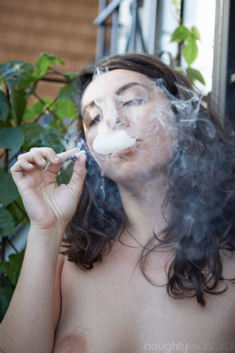 Amateur babe Nikki Silver smokes a spliff while posing undressed indoors and out