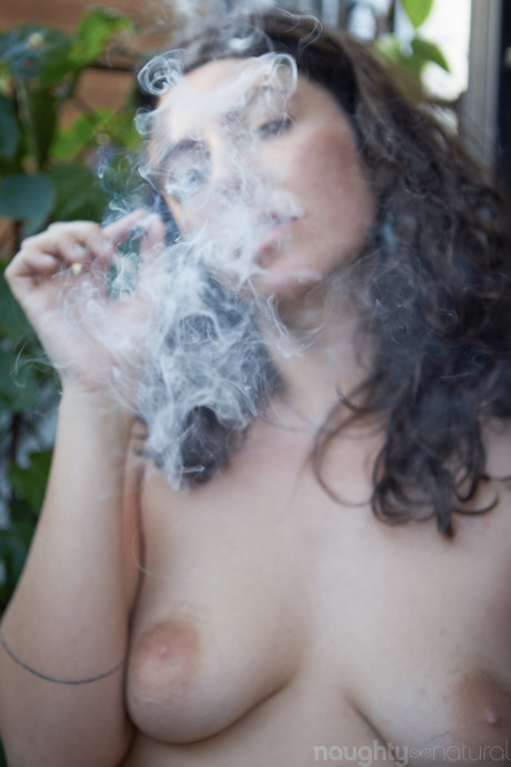 Amateur babe Nikki Silver smokes a spliff while posing undressed indoors and out