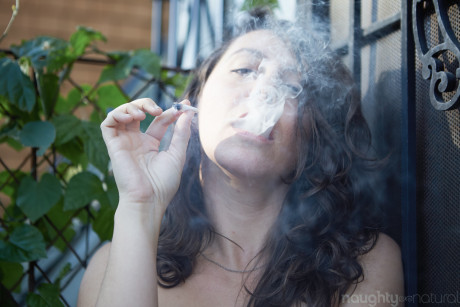 Amateur babe Nikki Silver smokes a spliff while posing undressed indoors and out
