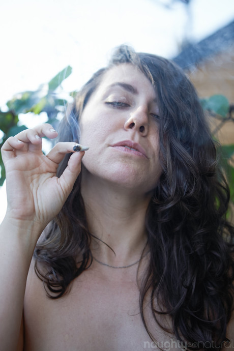 Amateur babe Nikki Silver smokes a spliff while posing undressed indoors and out