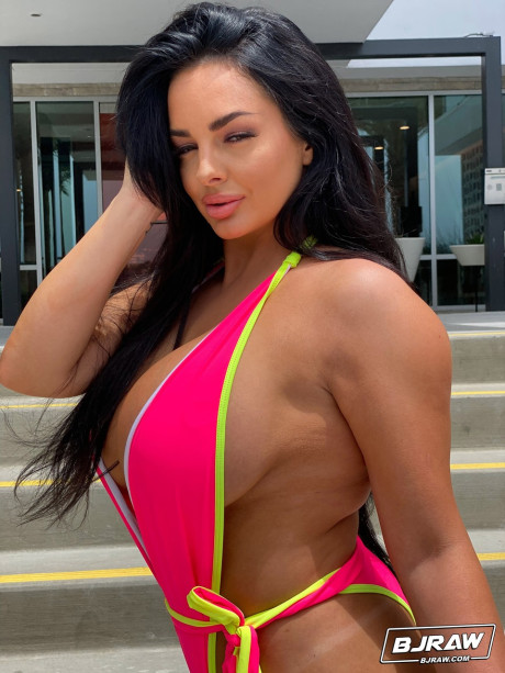Babe with grand breasts Jessica Annelle poses in a pink swimsuit outdoors
