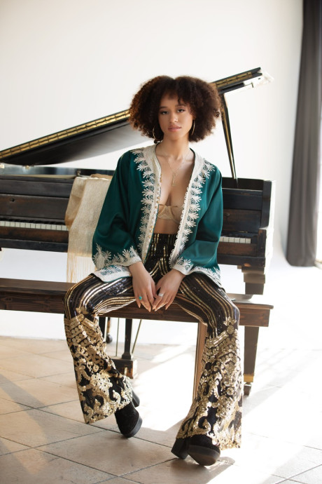 Ebony centerfold model Stormi Maya gets undressed in boots on a piano bench