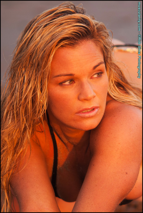 Blondie fitness model Michele Levesque poses on a beach in a tiny ebony bikini