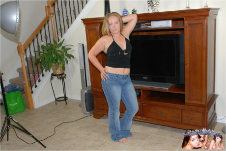 Yellow-haired amateur pulls down her jeans on a couch to show her snatch