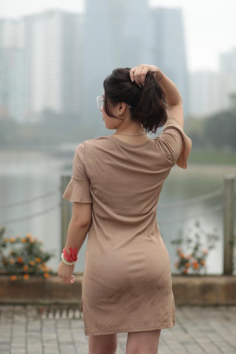 Thin oriental babe with eyeglasses posing in her tight skirt in public