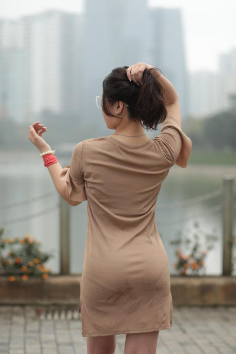 Thin oriental babe with eyeglasses posing in her tight skirt in public