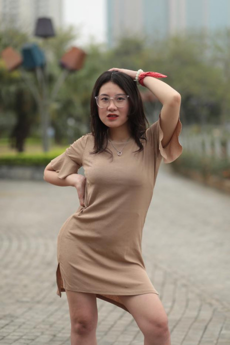 Thin oriental babe with eyeglasses posing in her tight skirt in public