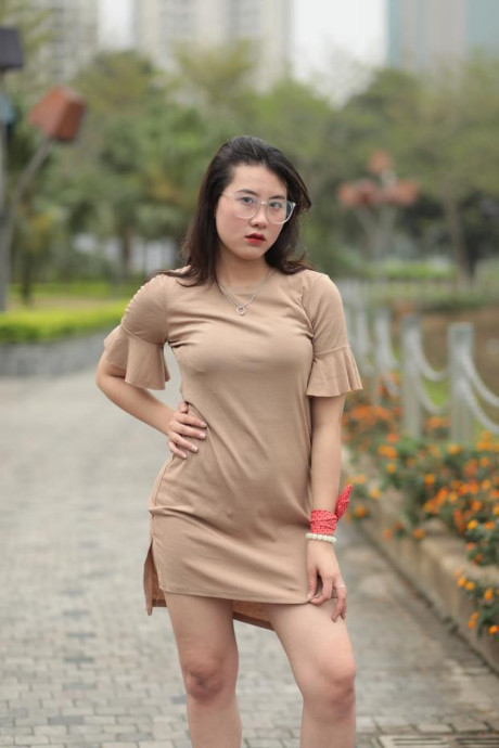 Thin oriental babe with eyeglasses posing in her tight skirt in public