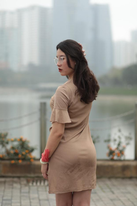 Thin oriental babe with eyeglasses posing in her tight skirt in public