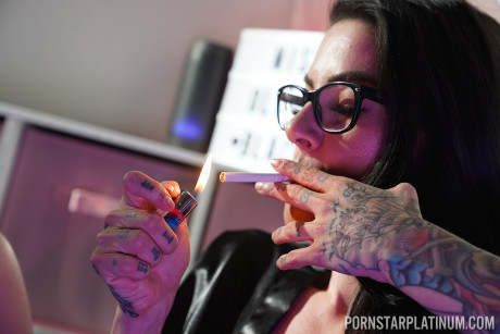 Inked pornstar Olivia black poses in enormous heels and negligee while smoking