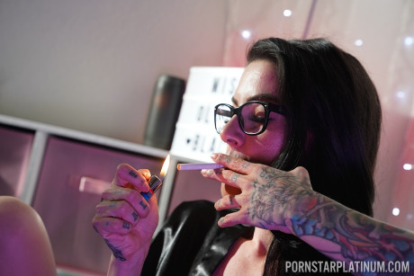 Inked pornstar Olivia black poses in enormous heels and negligee while smoking